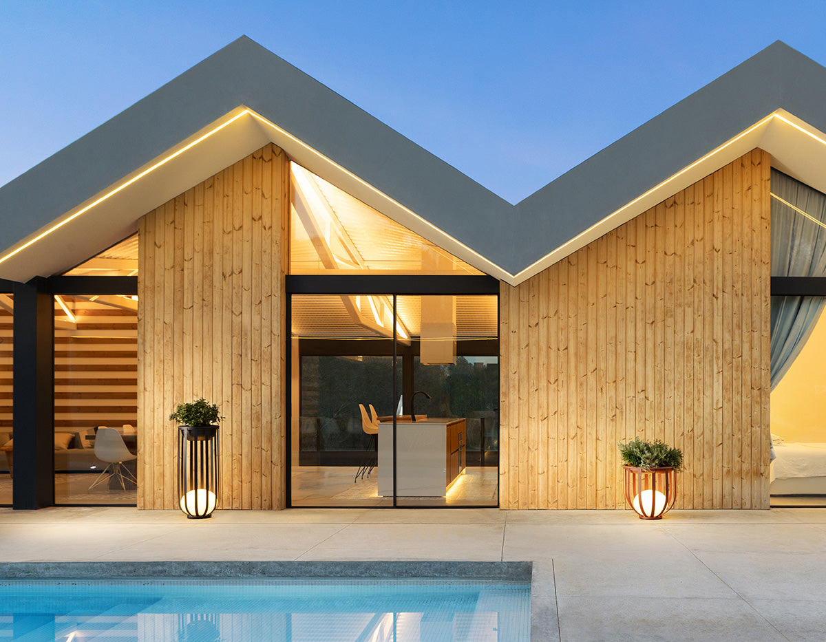 Bols outdoor floor lamps in tall black and short red outside modern house with pool