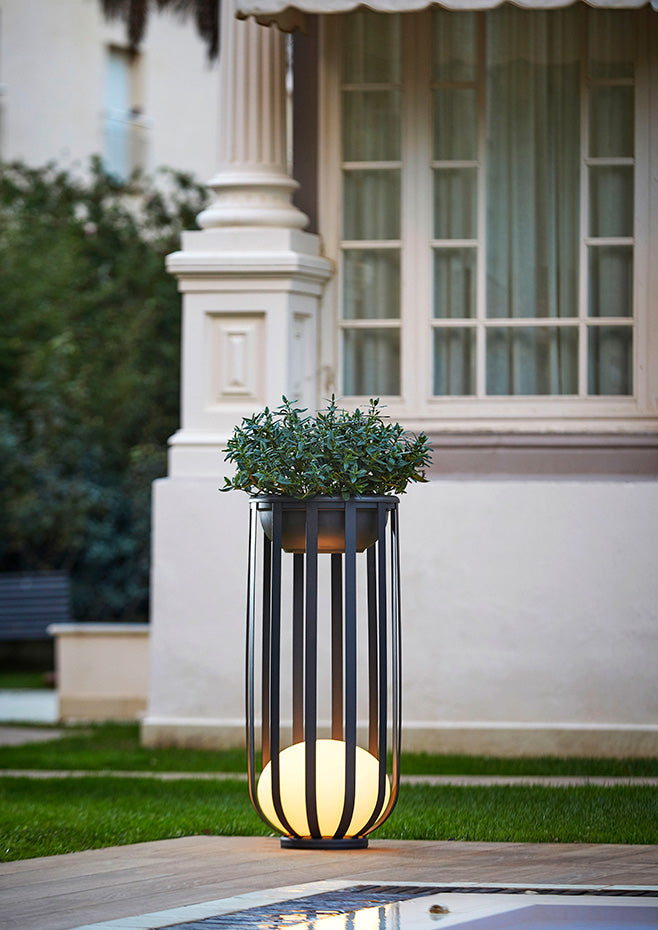 Bols outdoor floor lamp in black with deep potted plant accessory by pool