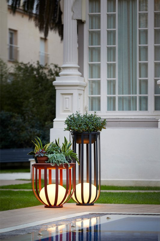 Bols outdoor floor lamps in short and tall in red and black by pool with flower trays