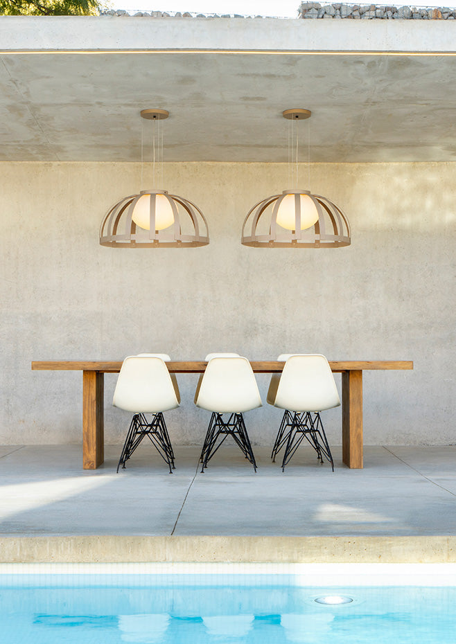Bols pendant lights doubled over outdoor dining table by pool