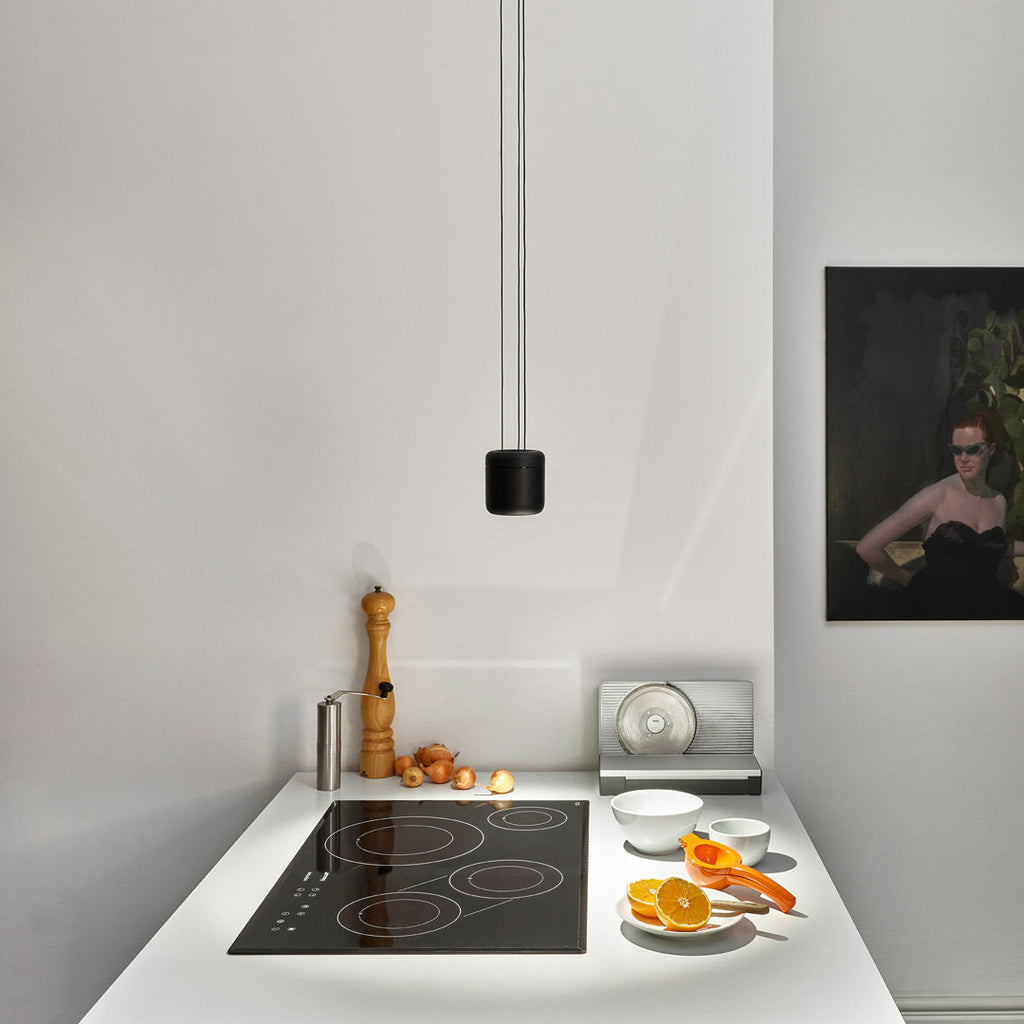 Cavity Pendant in Black Over Minimal Kitchen Hob Lit