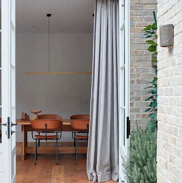Highline Linear Pendant in Brass over Casual Dining Table with High Ceilings