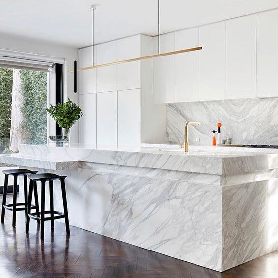 Highline Linear Pendant in Brass over White Marble Kitchen Island and Brass Tap