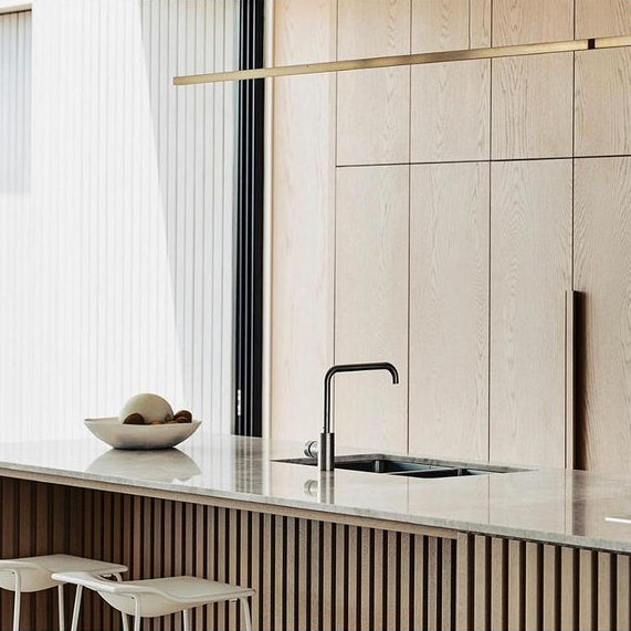 Highline Linear Pendant in Satin Brass over Kitchen Island with Wooden Slatted Base