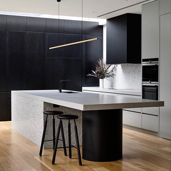 Highline Linear Pendant in Satin Brass over Modern Kitchen Island with Black Cabinets