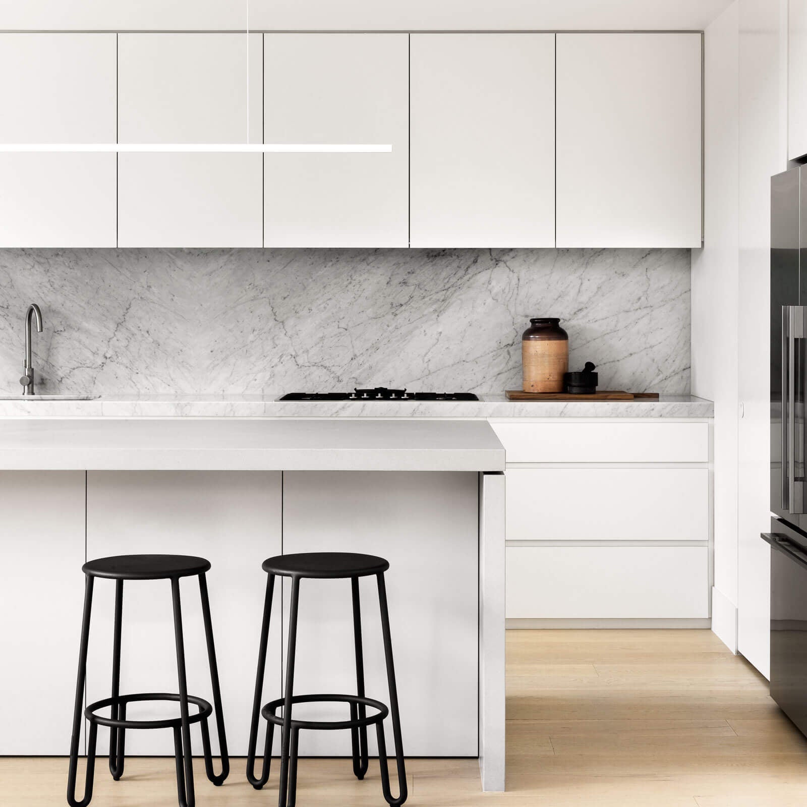 Highline Linear Pendant in White in White Kitchen with Black Stools