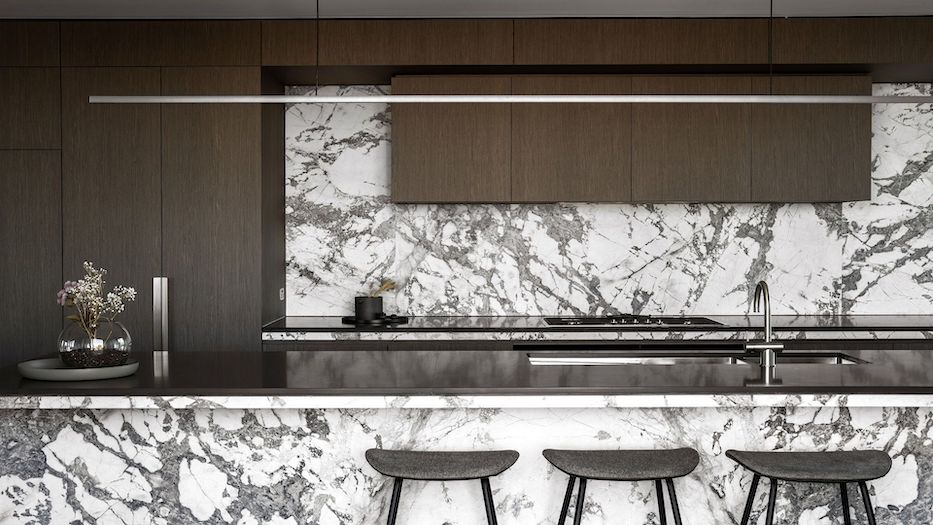 Highline Linear Pendant in White over Black Kitchen Island with Carrara Marble and Dark Cabinets